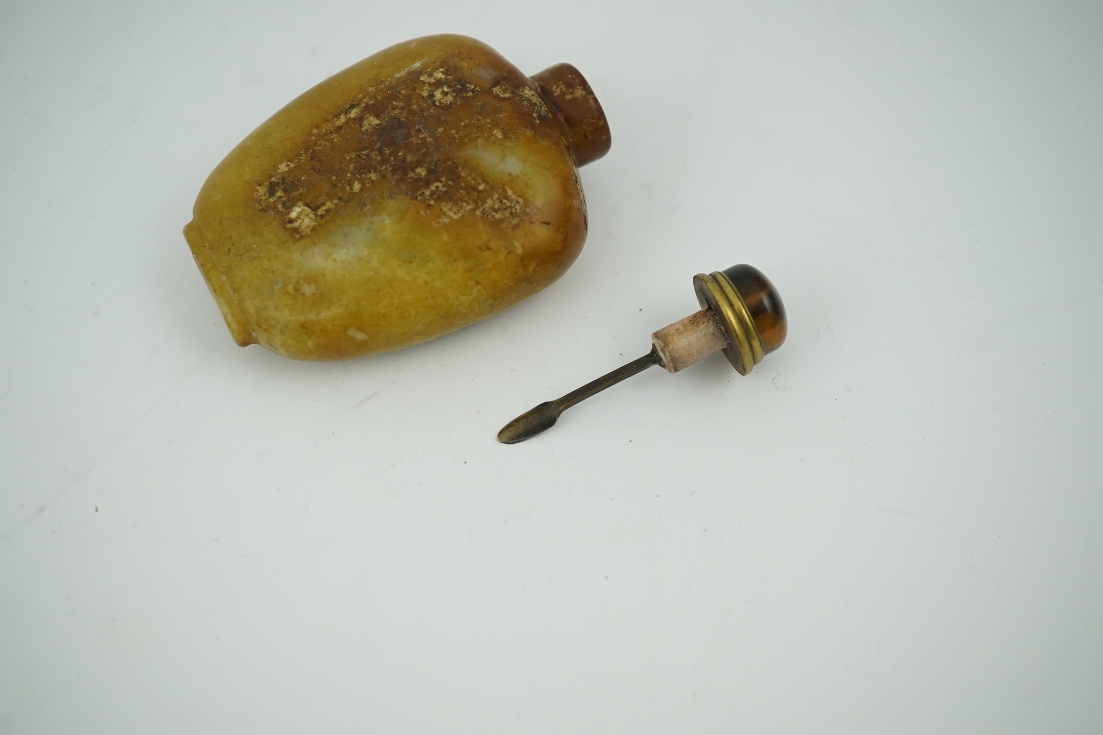 A Chinese soapstone snuff bottle with tiger's eye stopper, 8cm high. Condition - fair